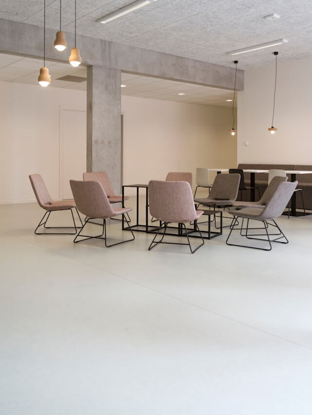 services-commercial-painting Modern office lounge with minimalist chairs and hanging lights