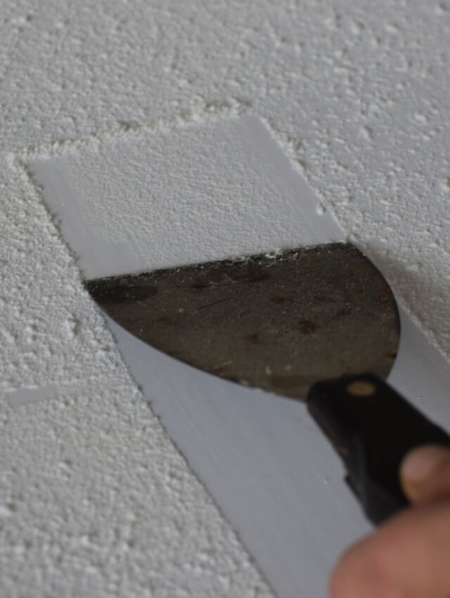 services-popcorn-texture-removal Removing popcorn ceiling texture with a scraper tool